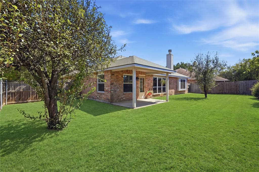 1125 Bayfield Drive, Denton, TX 76209 Expansive green lawn with mature trees and a covered patio