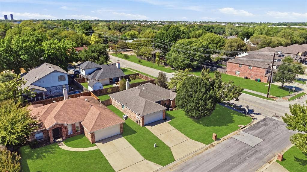 1125 Bayfield Drive, Denton, TX 76209 Brick exterior with an attached two-car garage, concrete driveway, and a gabled roof