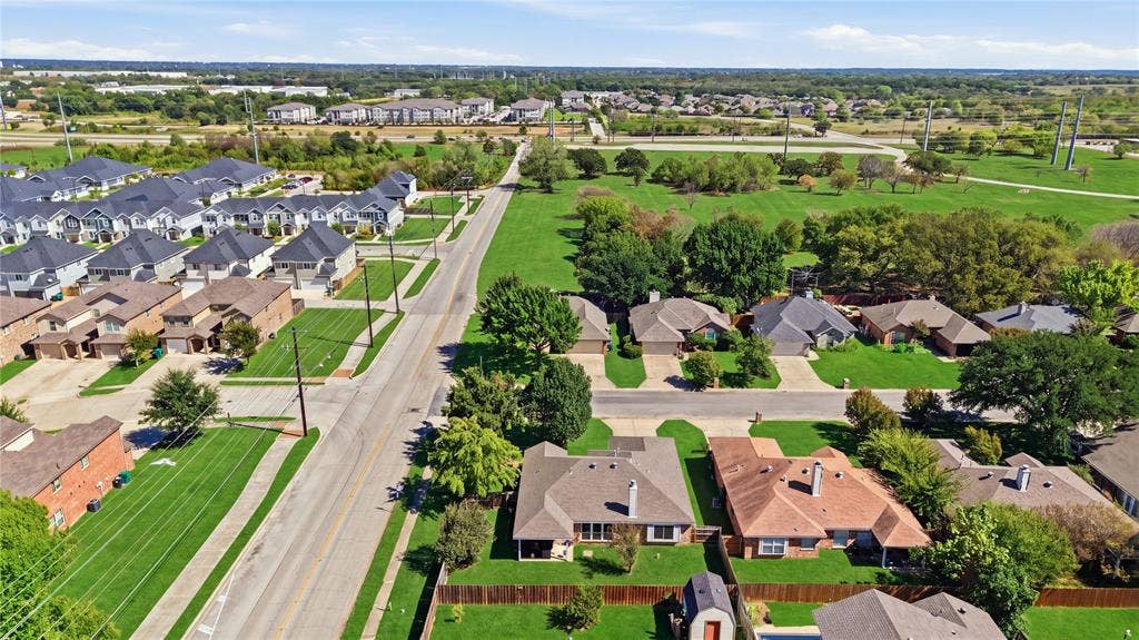 1125 Bayfield Drive, Denton, TX 76209 Aerial perspective showcasing residential properties with varied rooflines and a mix of mature and newly planted trees