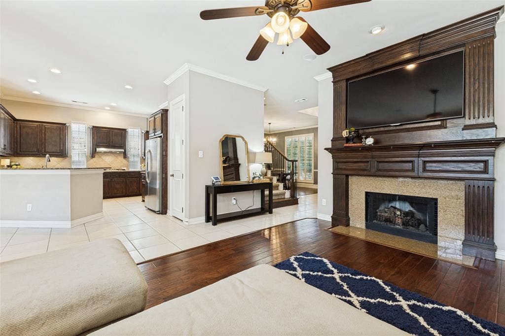 1227 Comanche Drive, Allen, TX 75013 Living area featuring a grand dark wood mantel with an integrated television space and a stone-surround fireplace