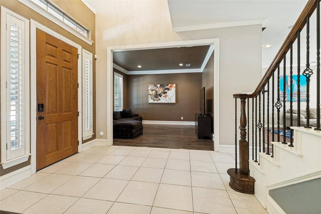 1227 Comanche Drive, Allen, TX 75013 Entryway featuring tile flooring, a wood-paneled door, and sidelight windows with plantation shutters