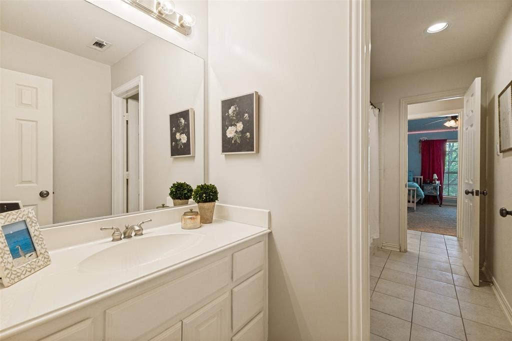 1227 Comanche Drive, Allen, TX 75013 White vanity with integrated sink, chrome faucet, and expansive wall-mounted mirror