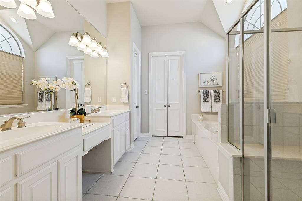 1227 Comanche Drive, Allen, TX 75013 Spacious bathroom featuring dual vanities with integrated sinks, a built-in soaking tub, and a glass-enclosed shower