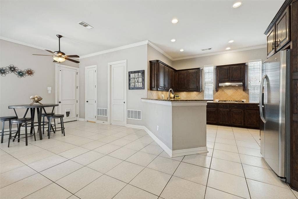 1227 Comanche Drive, Allen, TX 75013 Kitchen featuring dark wood cabinetry, stainless steel appliances, and tile flooring