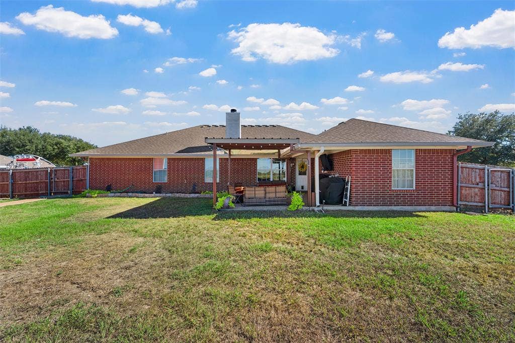 Brick exterior with a covered patio, fenced yard, and a single-story design