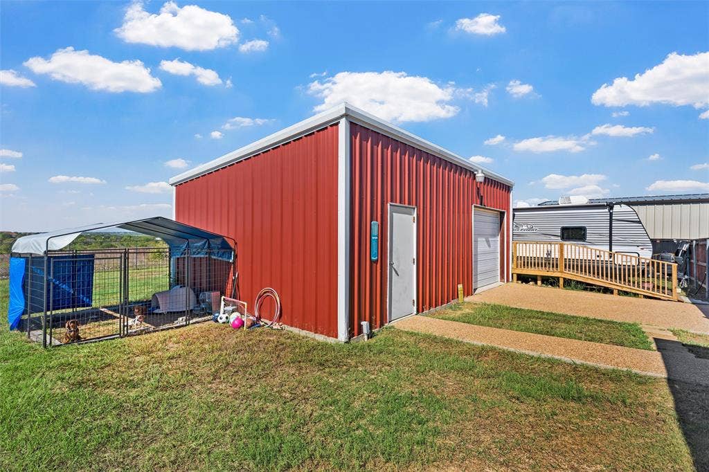 Red metal-sided structure with a side entrance and roll-up door