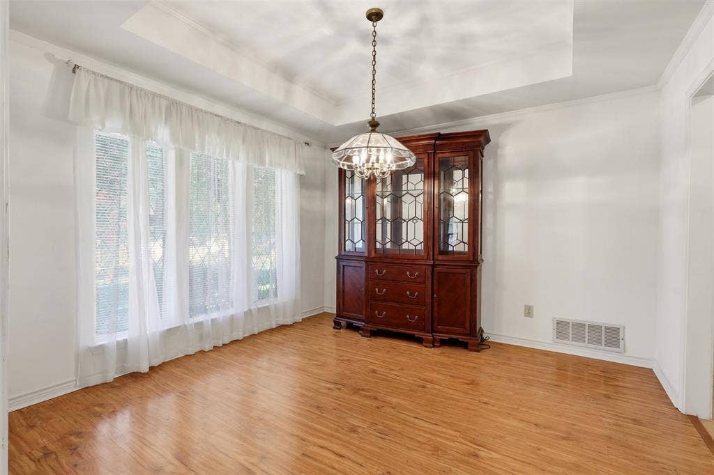 2700 Nighthawk Drive, Plano, TX 75025 Tray ceiling, wood-finish flooring, chandelier, multiple windows, and white walls