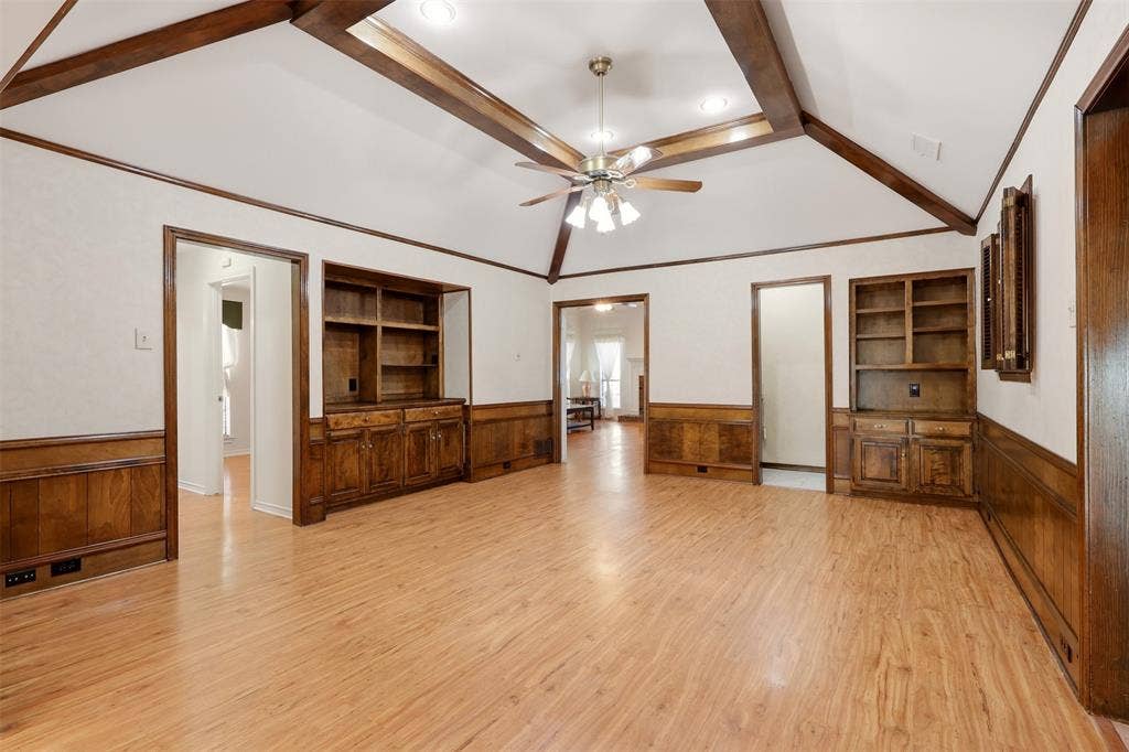 2700 Nighthawk Drive, Plano, TX 75025 Vaulted ceiling with exposed wood beams, wood-finish flooring, built-in cabinetry, and wood paneling