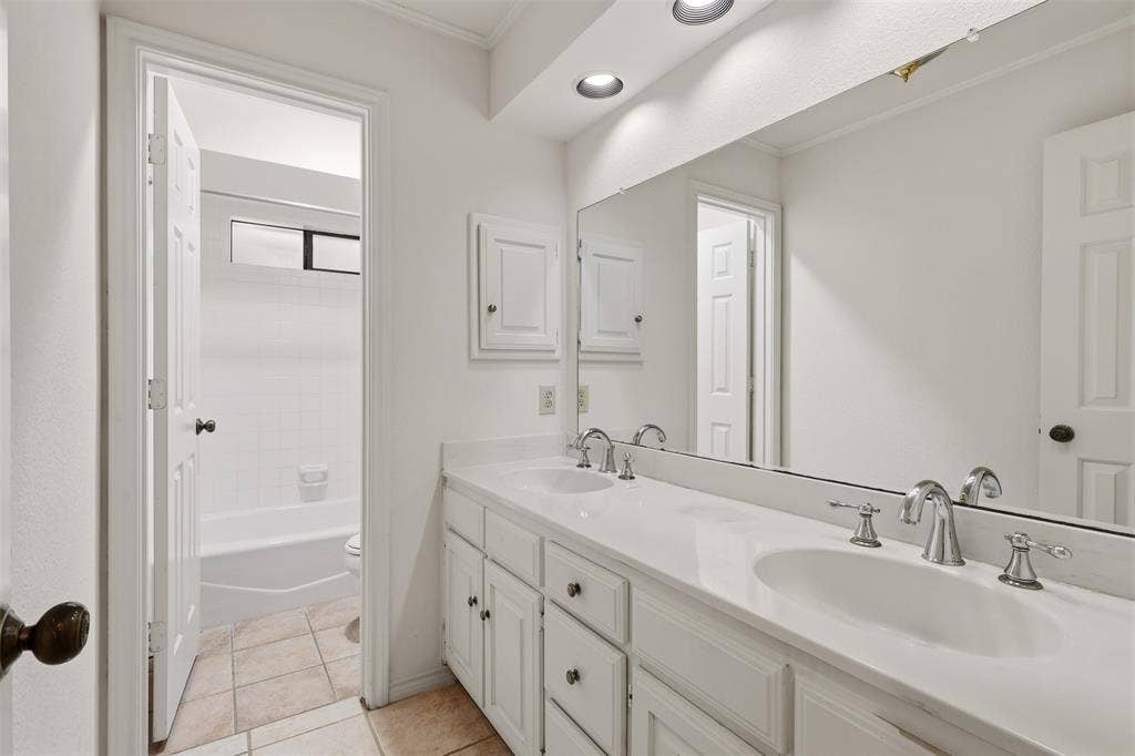 2700 Nighthawk Drive, Plano, TX 75025 Double vanity with integrated sinks, chrome fixtures, recessed lighting, and tiled flooring