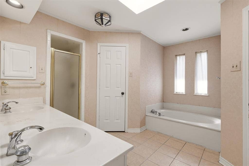 2700 Nighthawk Drive, Plano, TX 75025 Dual vanity with integrated sinks, built-in soaking tub, and a separate glass-enclosed shower