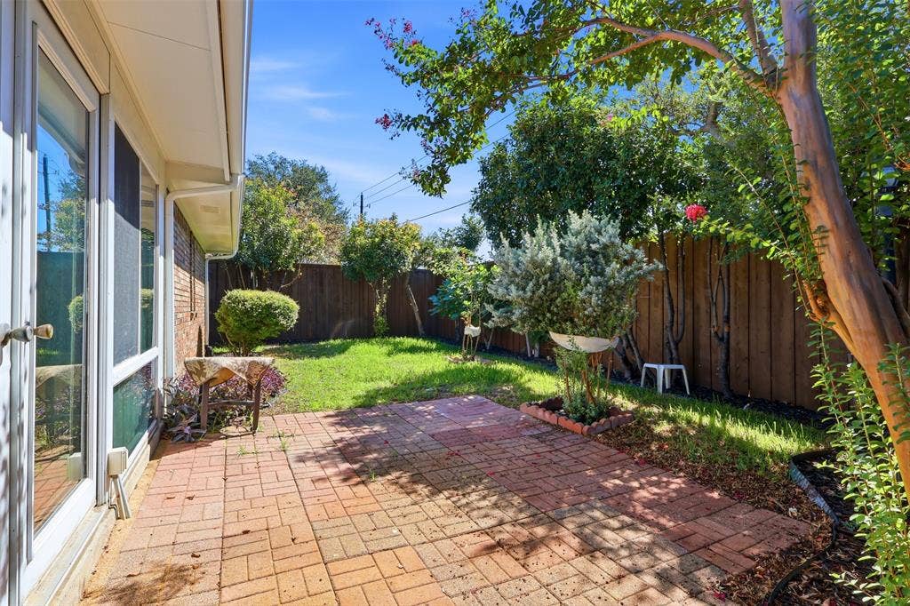 2700 Nighthawk Drive, Plano, TX 75025 Brick patio with a manicured lawn, mature trees, and privacy fencing