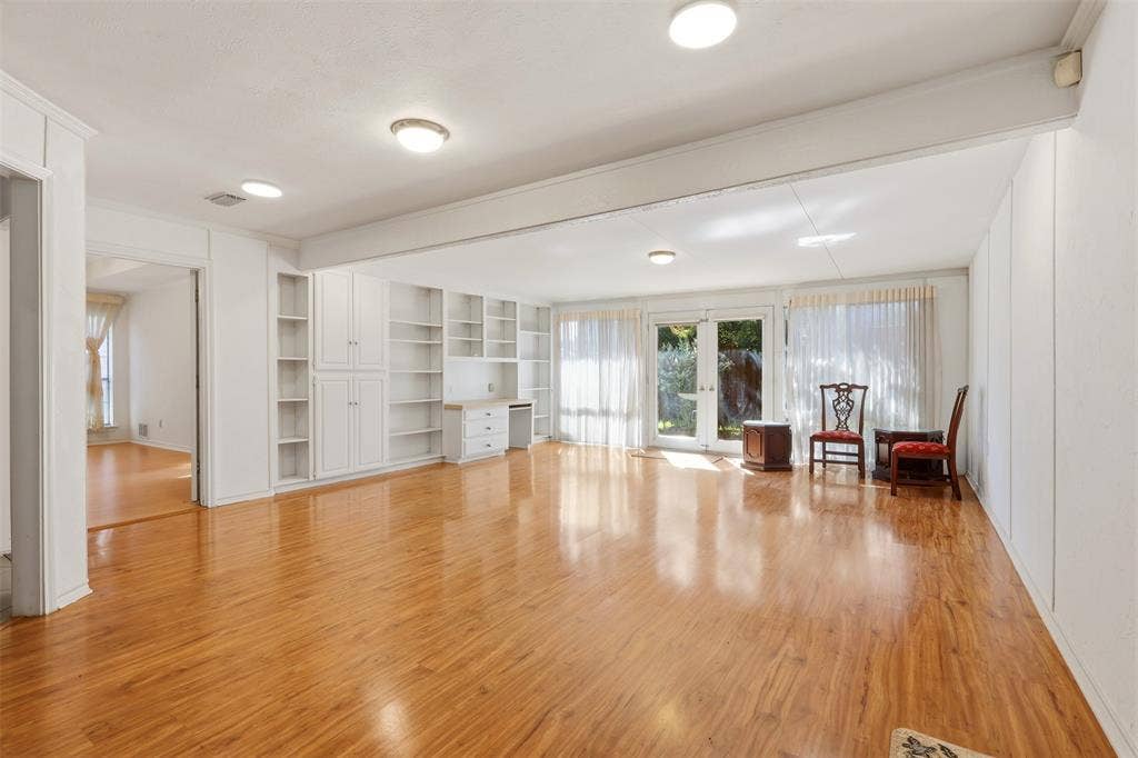 2700 Nighthawk Drive, Plano, TX 75025 Hardwood-finish flooring throughout, featuring built-in white cabinetry, recessed lighting, and double-paned glass doors