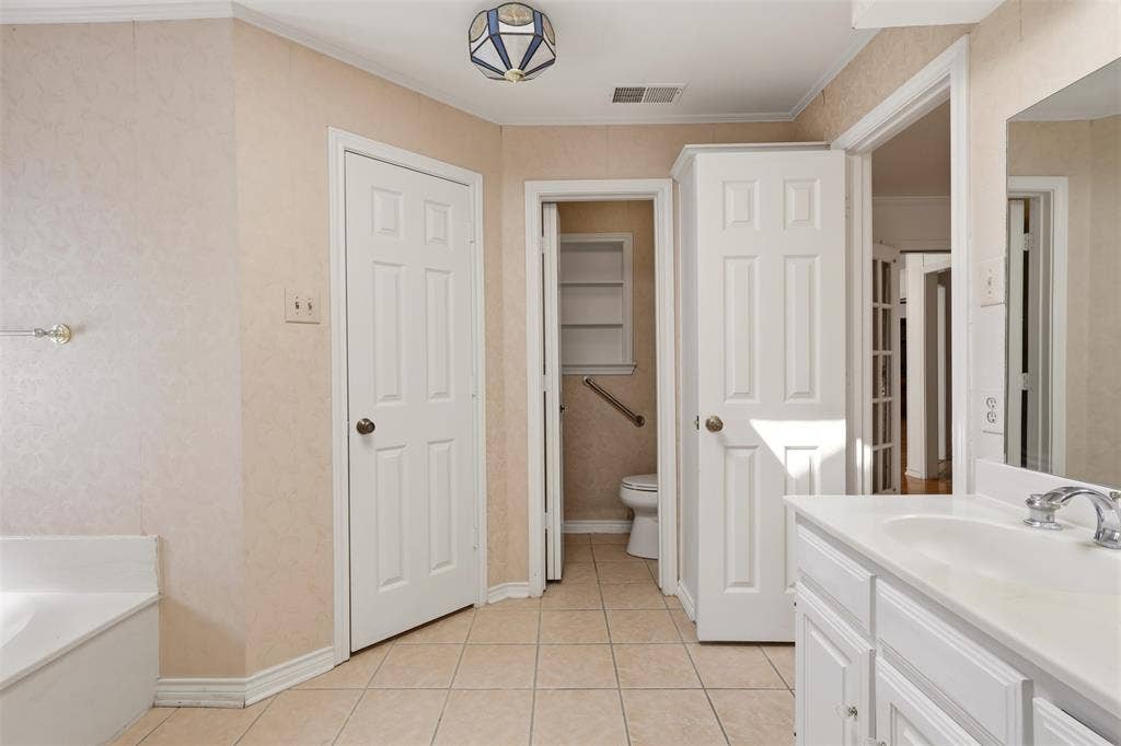 2700 Nighthawk Drive, Plano, TX 75025 Double vanity featuring white cabinetry and an integrated sink