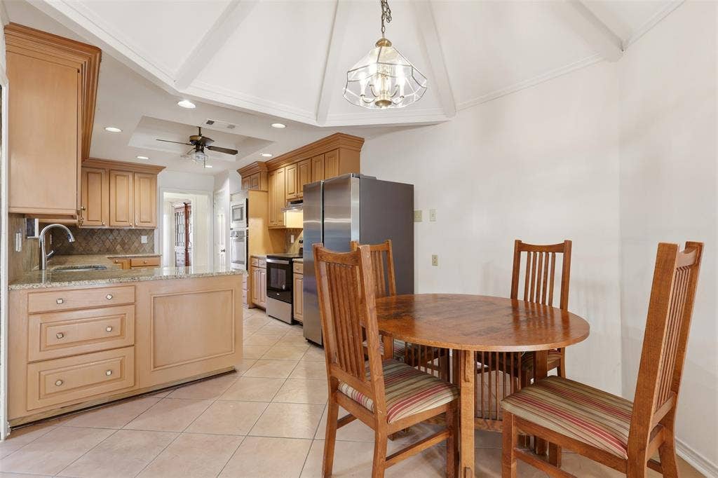 2700 Nighthawk Drive, Plano, TX 75025 Kitchen featuring wood cabinetry, light-toned tiled flooring, granite countertops, and stainless steel appliances