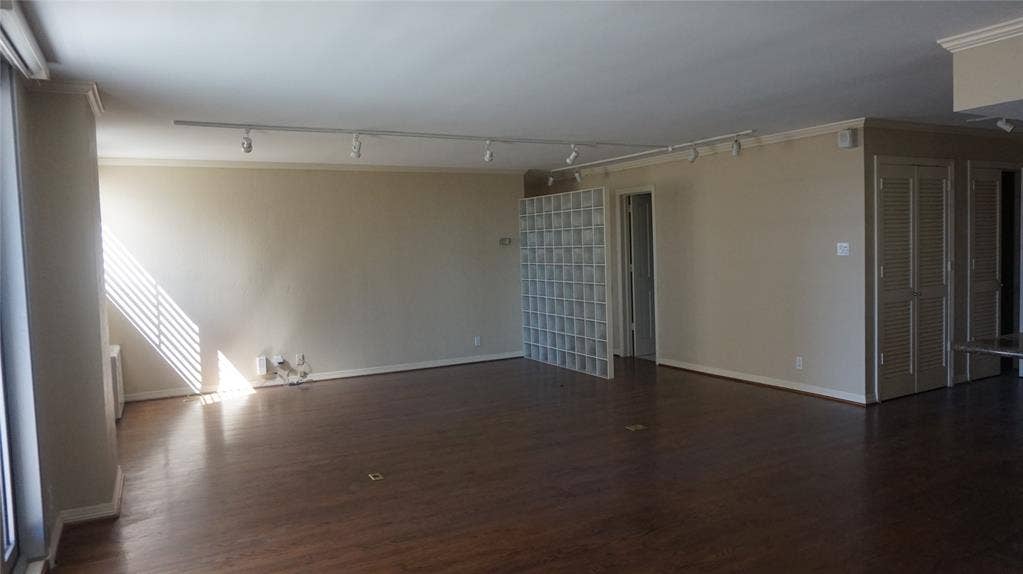 3883 Turtle Creek Boulevard, #1114, Dallas, TX 75219 Spacious room featuring wood-finish flooring, track lighting, and glass block partition