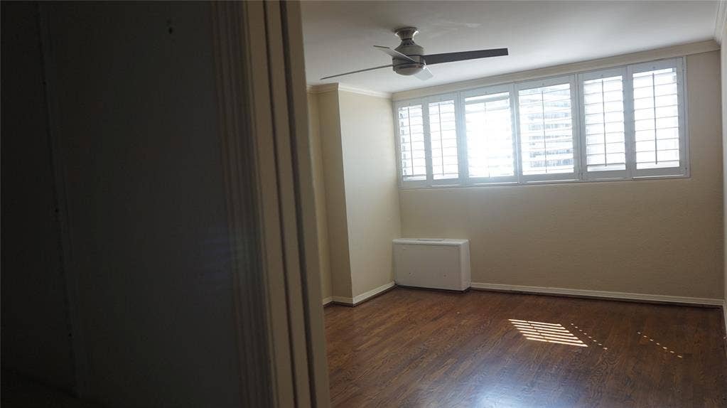 3883 Turtle Creek Boulevard, #1114, Dallas, TX 75219 Hardwood-style flooring, a ceiling fan, and window shutters