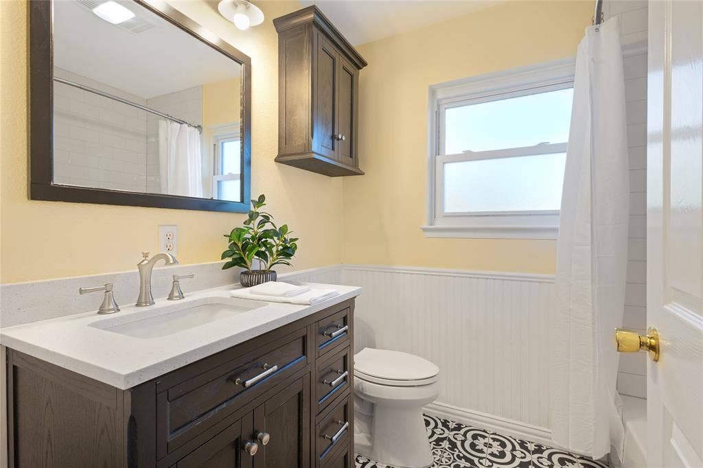 Dark wood-finish vanity with a light-colored countertop and integrated sink