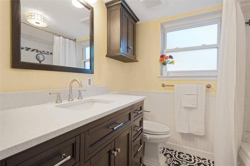 Dark wood-finish vanity with a light-toned countertop and an undermount sink