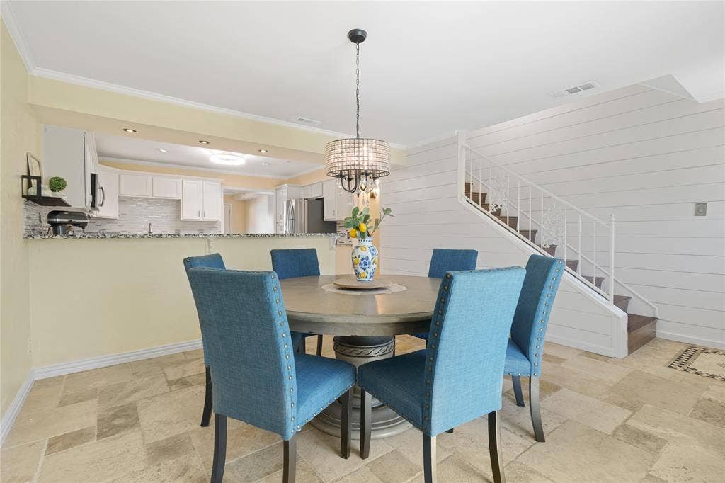 Open-concept dining area with tile flooring and a decorative chandelier