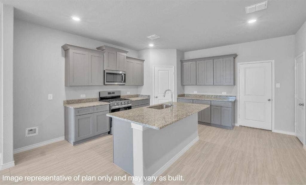 3308 Blue Jay Way, Richland Hills, TX 76118 Central island with an undermount sink, granite-style countertops, gray cabinetry, stainless steel range, and wood-finish flooring