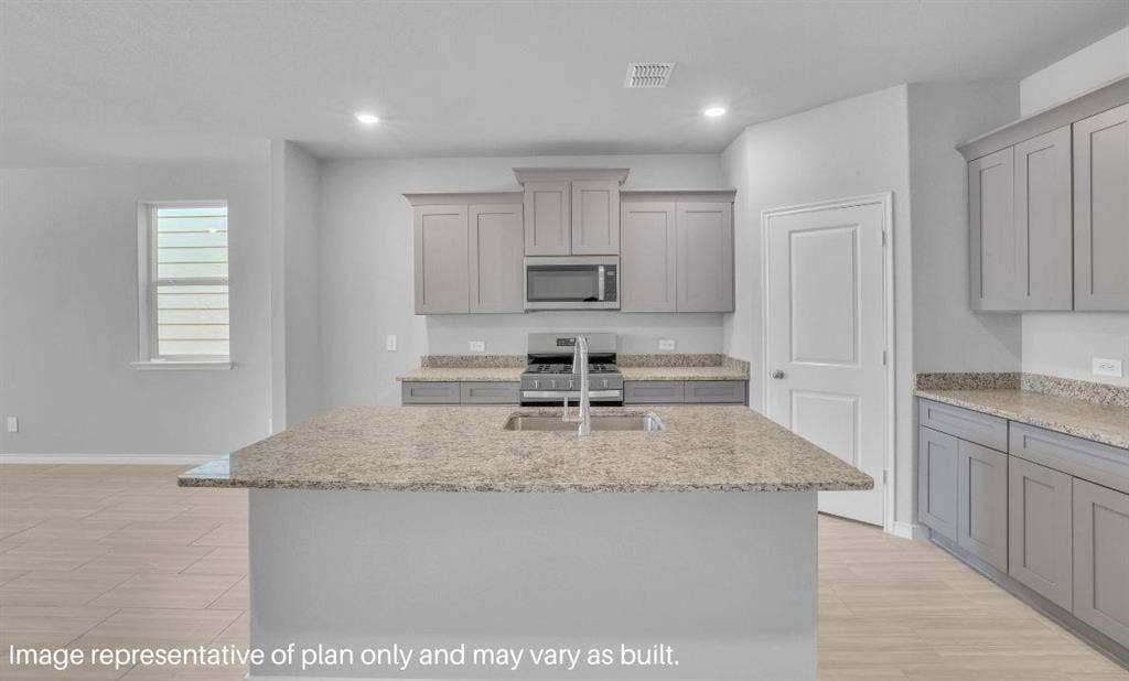 3308 Blue Jay Way, Richland Hills, TX 76118 Kitchen featuring a central island, stainless steel appliances, light-toned cabinetry, and wood-finish flooring