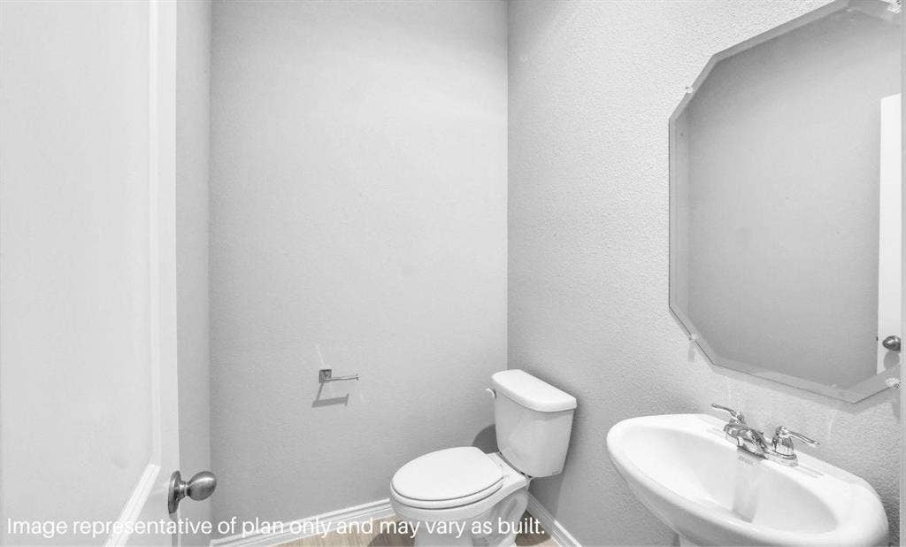 3308 Blue Jay Way, Richland Hills, TX 76118 Pedestal sink with chrome fixtures, octagonal frameless mirror, and wood-finish flooring