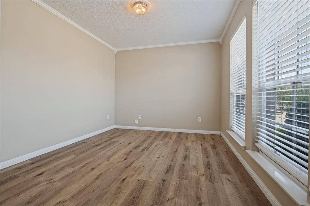 1308 Arbordale Court, Lancaster, TX 75134 Wood-finish flooring, neutral wall paint, white crown molding, white window trim, and white horizontal blinds