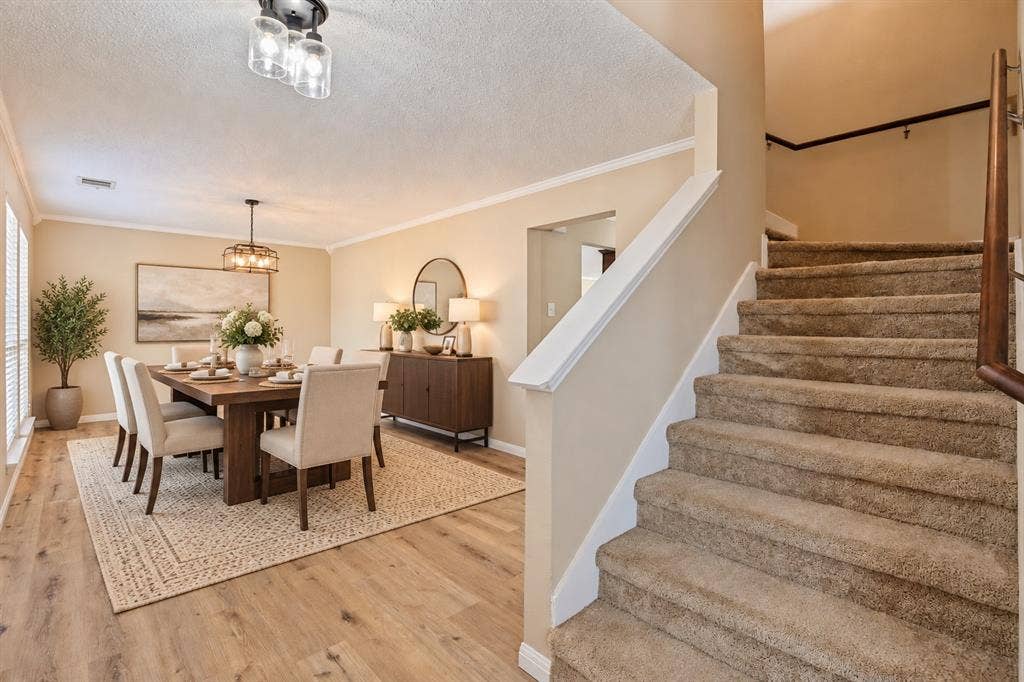 1308 Arbordale Court, Lancaster, TX 75134 Wood-finish flooring throughout the dining area, featuring a decorative chandelier and window blinds