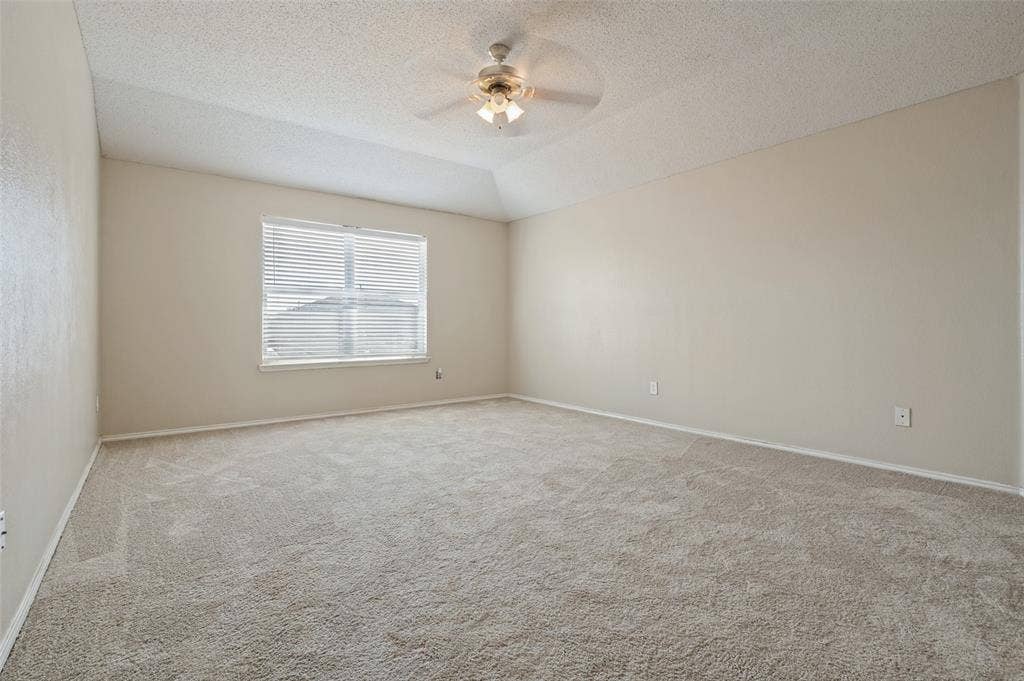 1308 Arbordale Court, Lancaster, TX 75134 Vaulted ceiling with an attached ceiling fan, large window with horizontal blinds, and carpeting throughout