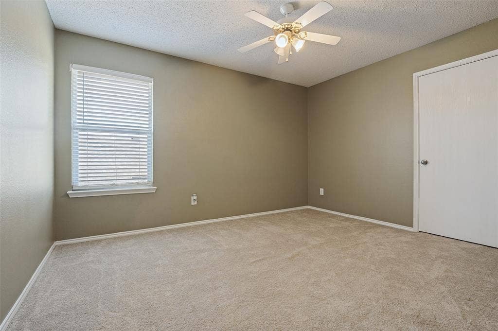 1308 Arbordale Court, Lancaster, TX 75134 Carpeted flooring, neutral wall tones, window with horizontal blinds, ceiling fan with integrated lighting, and a white door with a round knob