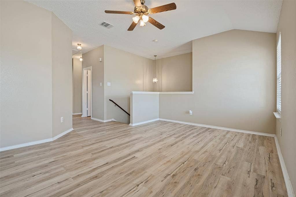 1308 Arbordale Court, Lancaster, TX 75134 Vaulted ceiling with a ceiling fan, wood-finish flooring, and neutral wall tones