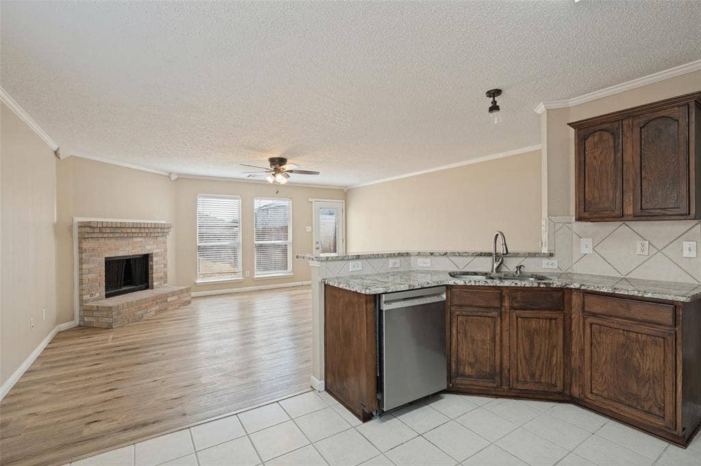 1308 Arbordale Court, Lancaster, TX 75134 Kitchen featuring granite countertops, wood cabinetry, stainless steel dishwasher, and a tile backsplash