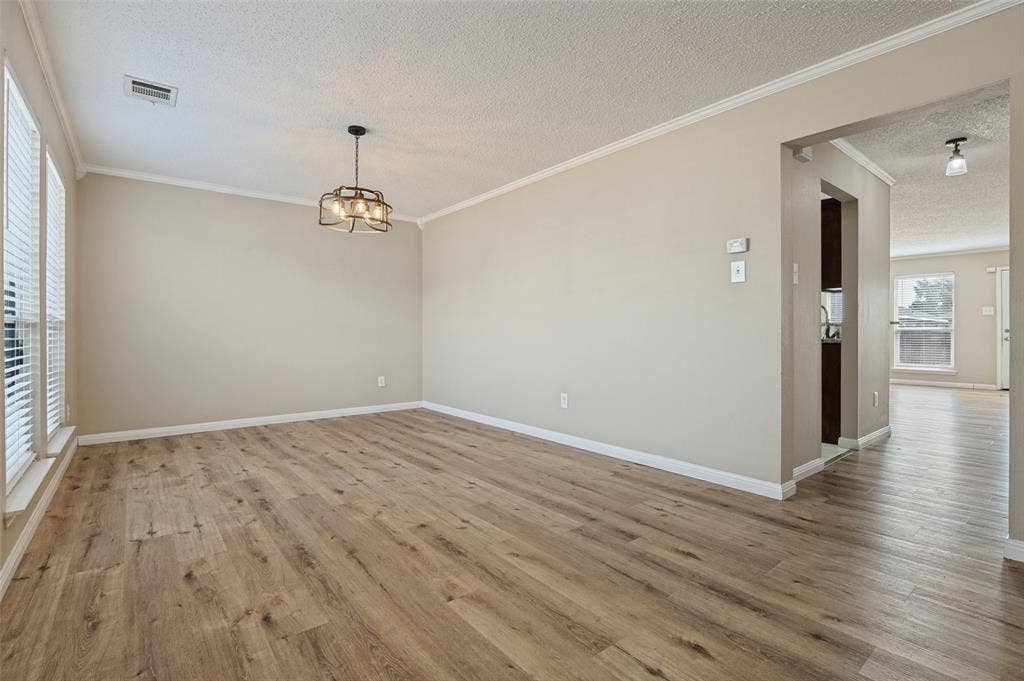 1308 Arbordale Court, Lancaster, TX 75134 Wood-finish flooring, crown molding, modern light fixture, window blinds, and neutral wall tones