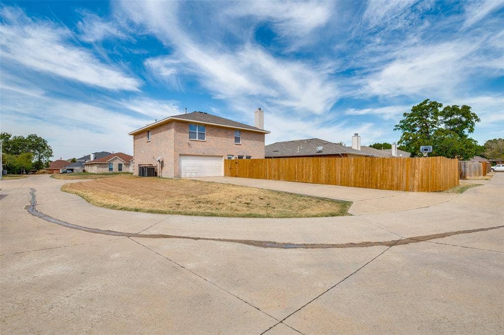 1308 Arbordale Court, Lancaster, TX 75134 Brick exterior construction with an attached garage, a wooden privacy fence, and a concrete driveway