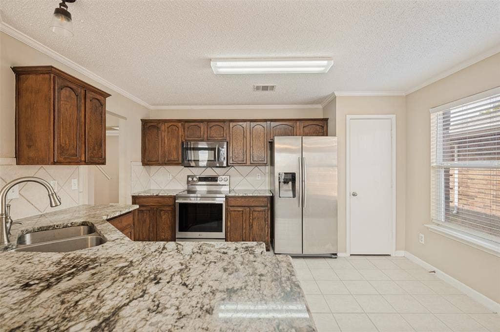 1308 Arbordale Court, Lancaster, TX 75134 Kitchen featuring wood cabinetry, stainless steel appliances, and a double basin sink