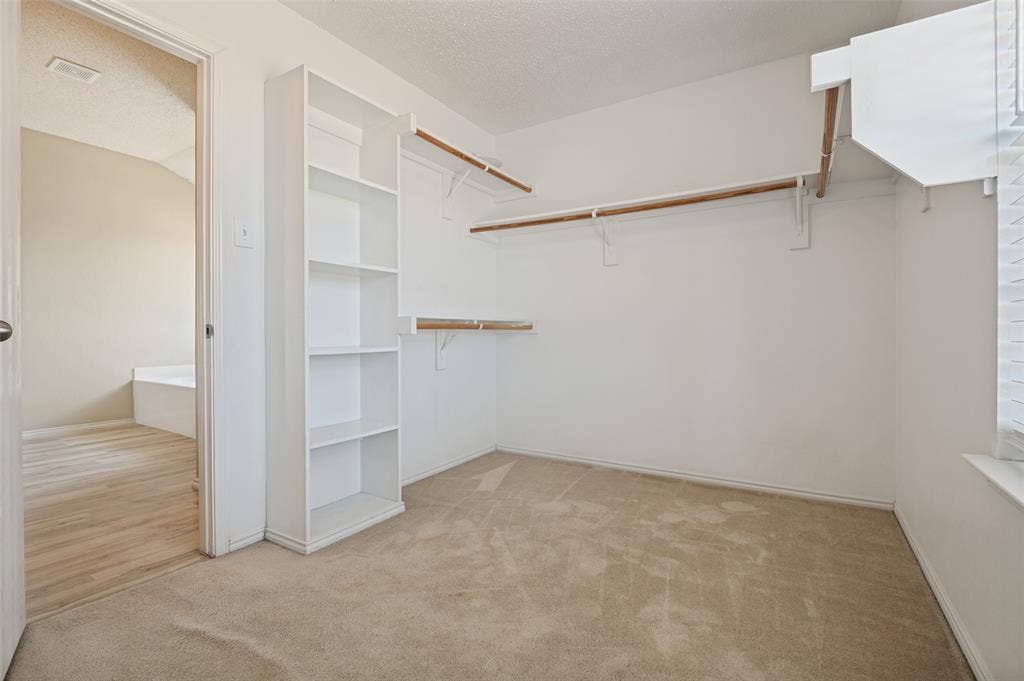 1308 Arbordale Court, Lancaster, TX 75134 Walk-in closet featuring carpet flooring, built-in shelving, two clothing rods, and a window for natural light