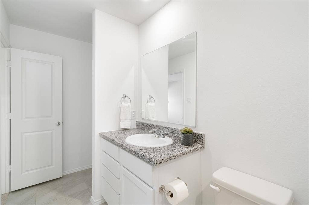 250 Herman Lane, Princeton, TX 75407 White vanity with a granite countertop, integrated sink, and chrome faucet