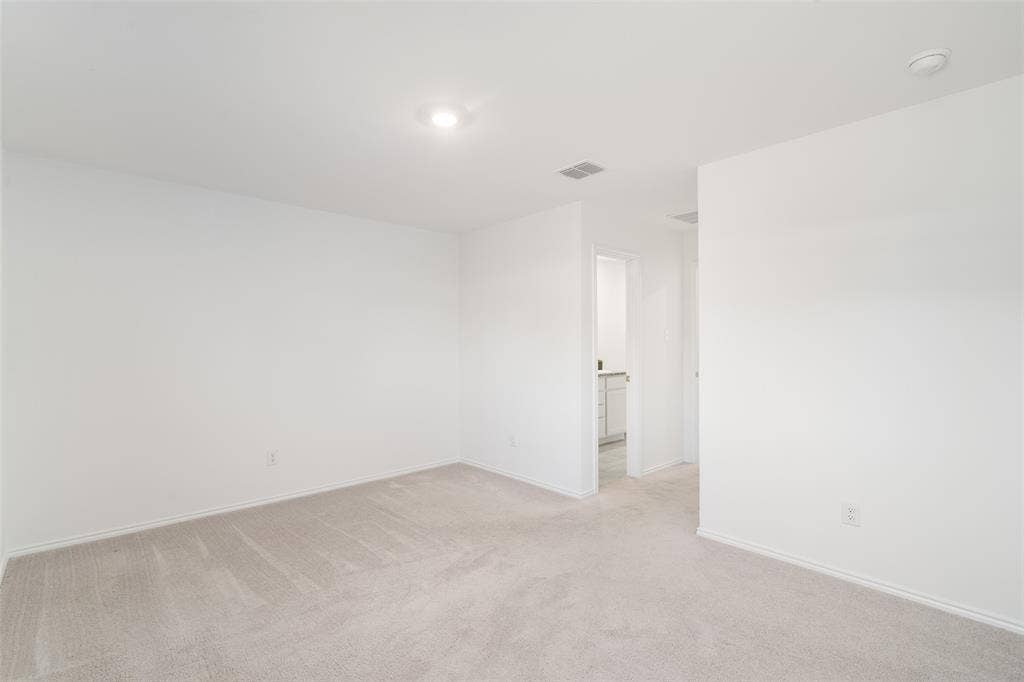 250 Herman Lane, Princeton, TX 75407 Spacious room featuring neutral carpeting and white wall finishes, with recessed lighting and a doorway leading to an additional space