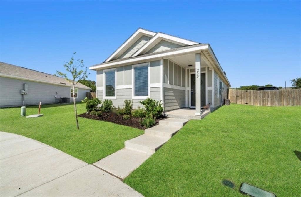 250 Herman Lane, Princeton, TX 75407 Single-story residence featuring light gray siding, white trim, a covered porch entry, and a concrete walkway