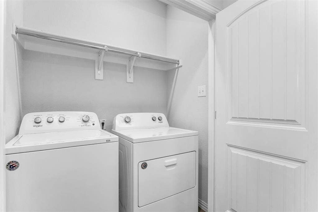 Laundry area featuring a built-in shelf with hanging rod and a white beadboard door