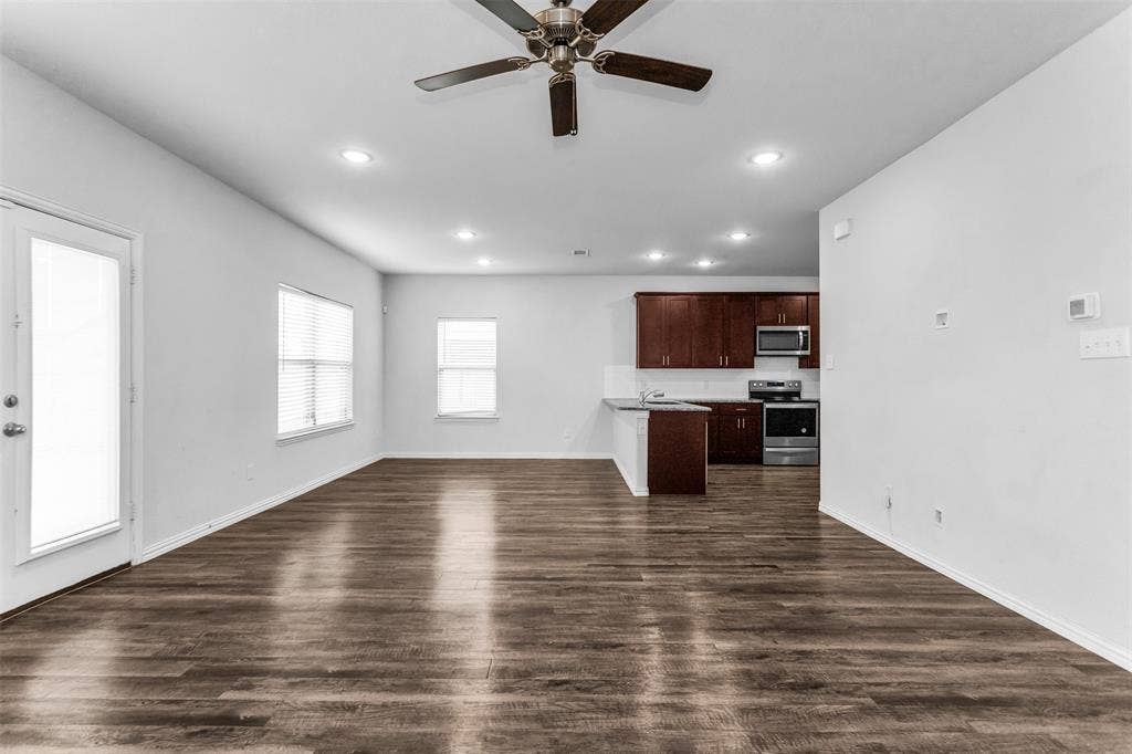 Open-concept living space featuring wood-finish flooring, recessed lighting, and a ceiling fan