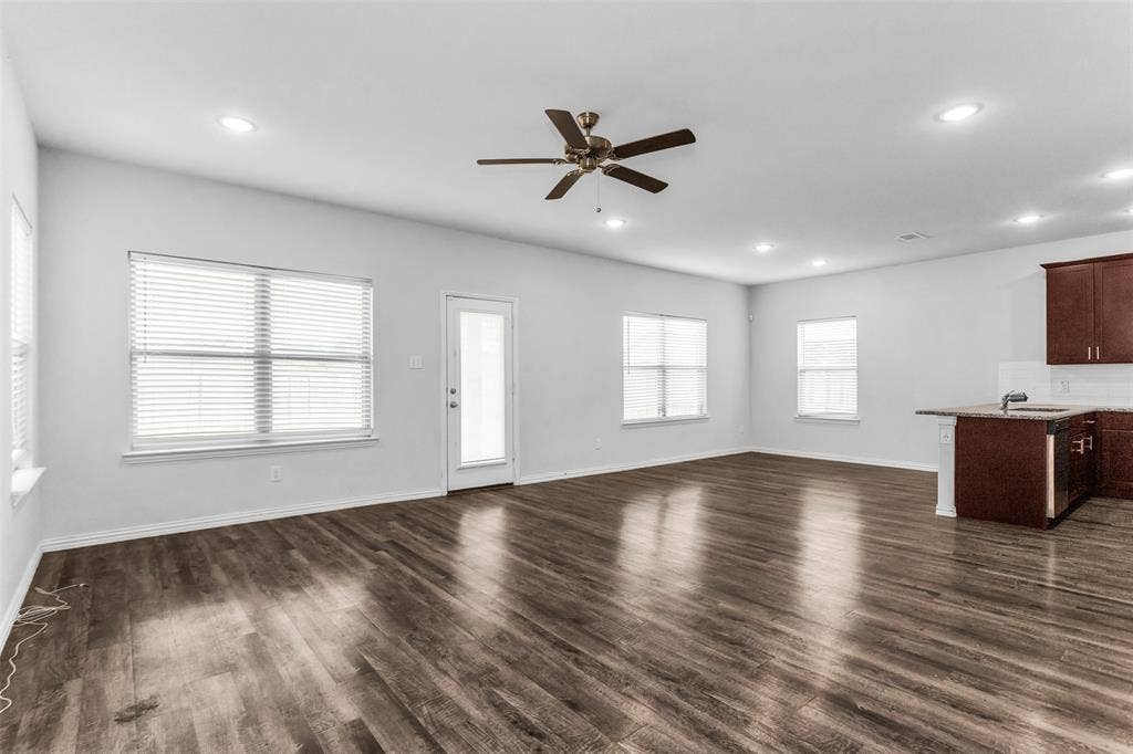 Spacious living area featuring wood-finish flooring, recessed lighting, and a ceiling fan
