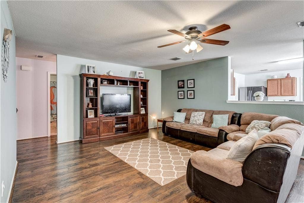 12829 Pricklybranch Drive, Fort Worth, TX 76244 Expansive living area featuring wood-finish flooring, a ceiling fan with integrated lighting, and a built-in entertainment center
