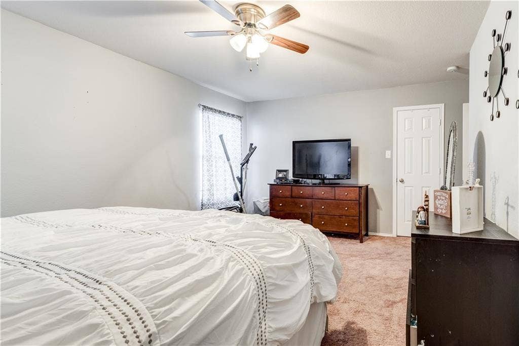 12829 Pricklybranch Drive, Fort Worth, TX 76244 Ceiling fan with light kit, neutral wall paint, white trim, window with patterned blinds, and a white interior door