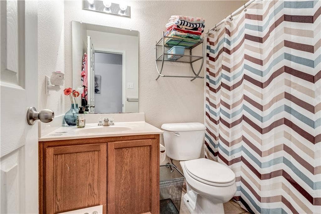 12829 Pricklybranch Drive, Fort Worth, TX 76244 Wood-finish vanity with a white countertop and integrated sink