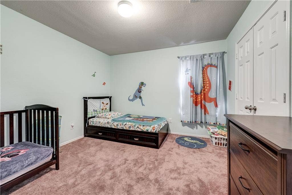 12829 Pricklybranch Drive, Fort Worth, TX 76244 Neutral wall color, carpeted flooring, window with curtain rod, and white bi-fold closet doors