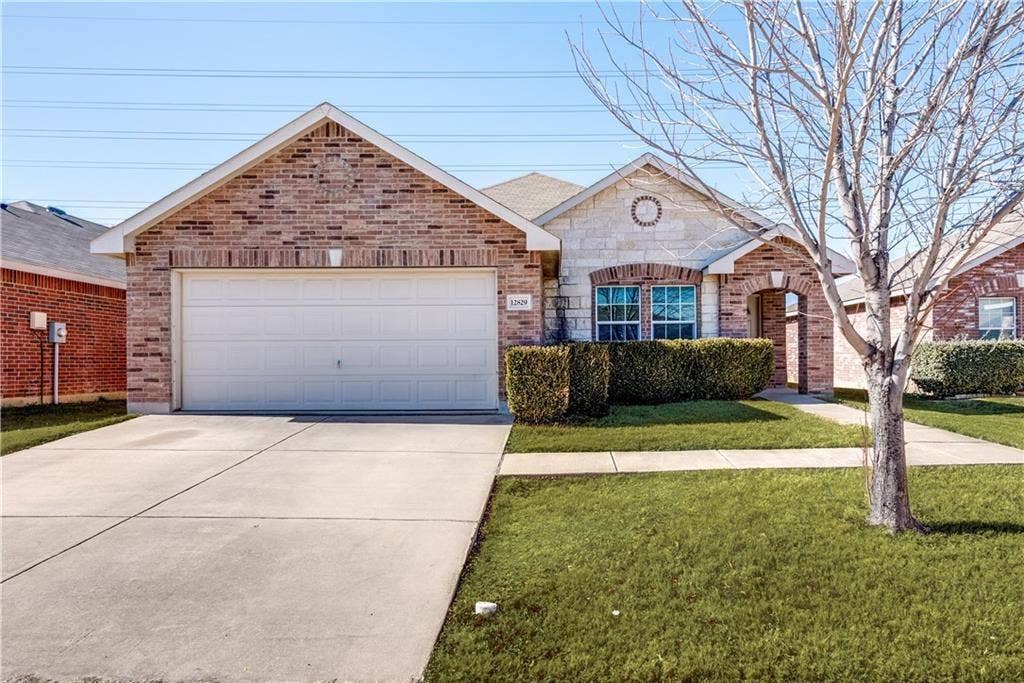 12829 Pricklybranch Drive, Fort Worth, TX 76244 Brick and stone facade, two-car garage, concrete driveway, arched entryway, and front landscaping