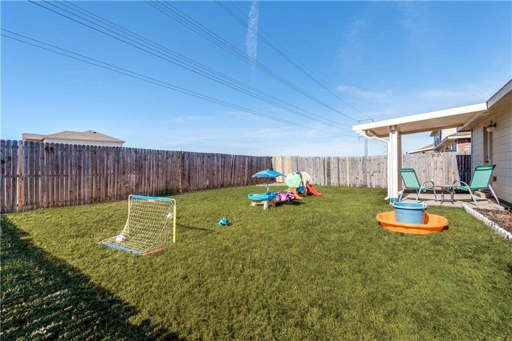 12829 Pricklybranch Drive, Fort Worth, TX 76244 Expansive backyard featuring a covered patio, established lawn, and a wood privacy fence