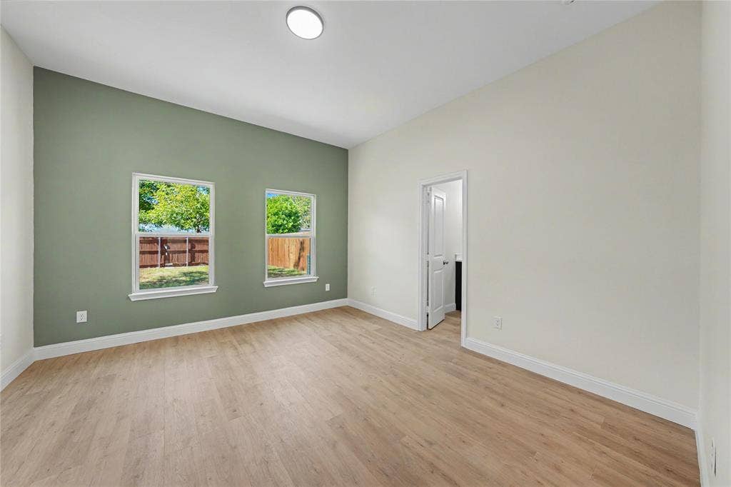 817 Stamps Avenue, Fort Worth, TX 76114 Light wood-finish flooring, recessed ceiling lighting, a prominent accent wall, and two windows