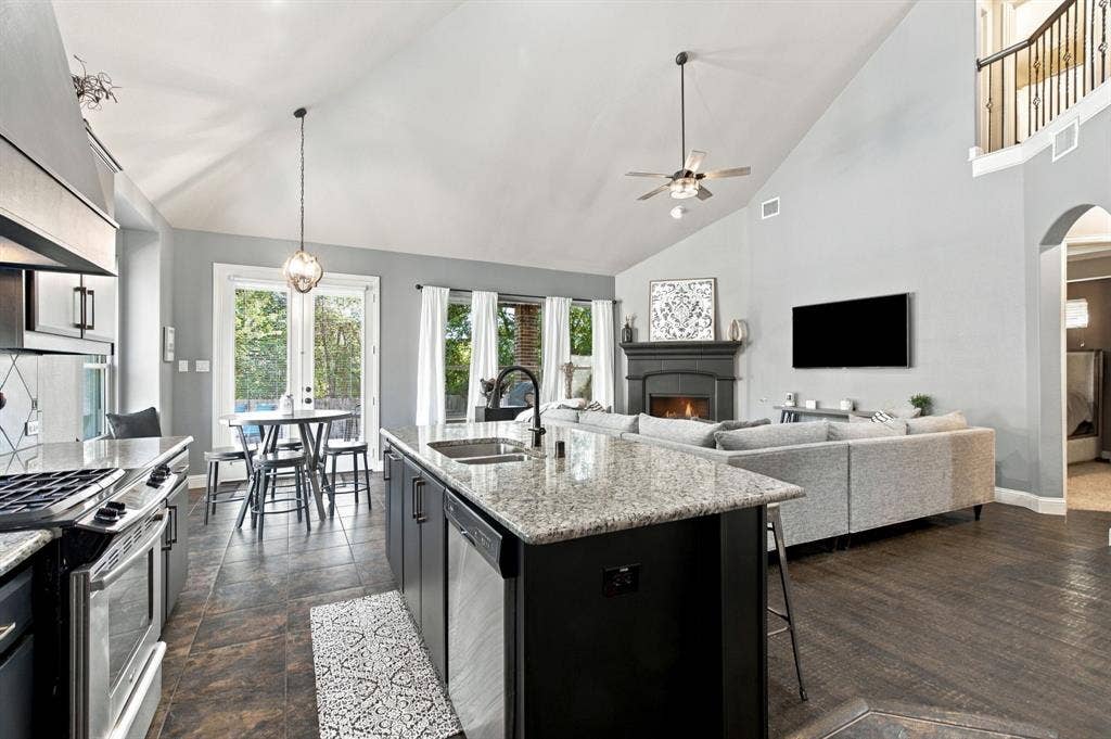An oversized granite island with an undermount sink anchors the kitchen, which opens directly to the living room and breakfast area for easy conversation and gathering.